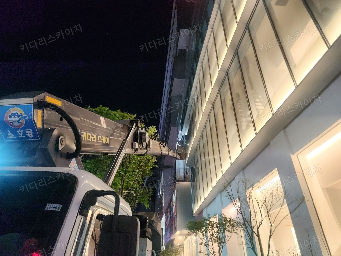조명이 켜진 상가 외벽 앞 야간 장비 배치