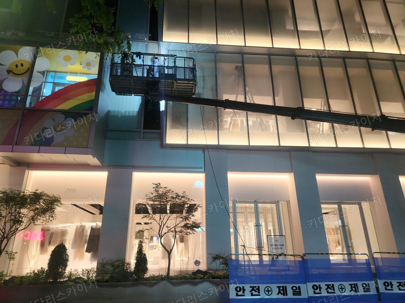 조명이 켜진 상가 외벽 앞 야간 장비 배치