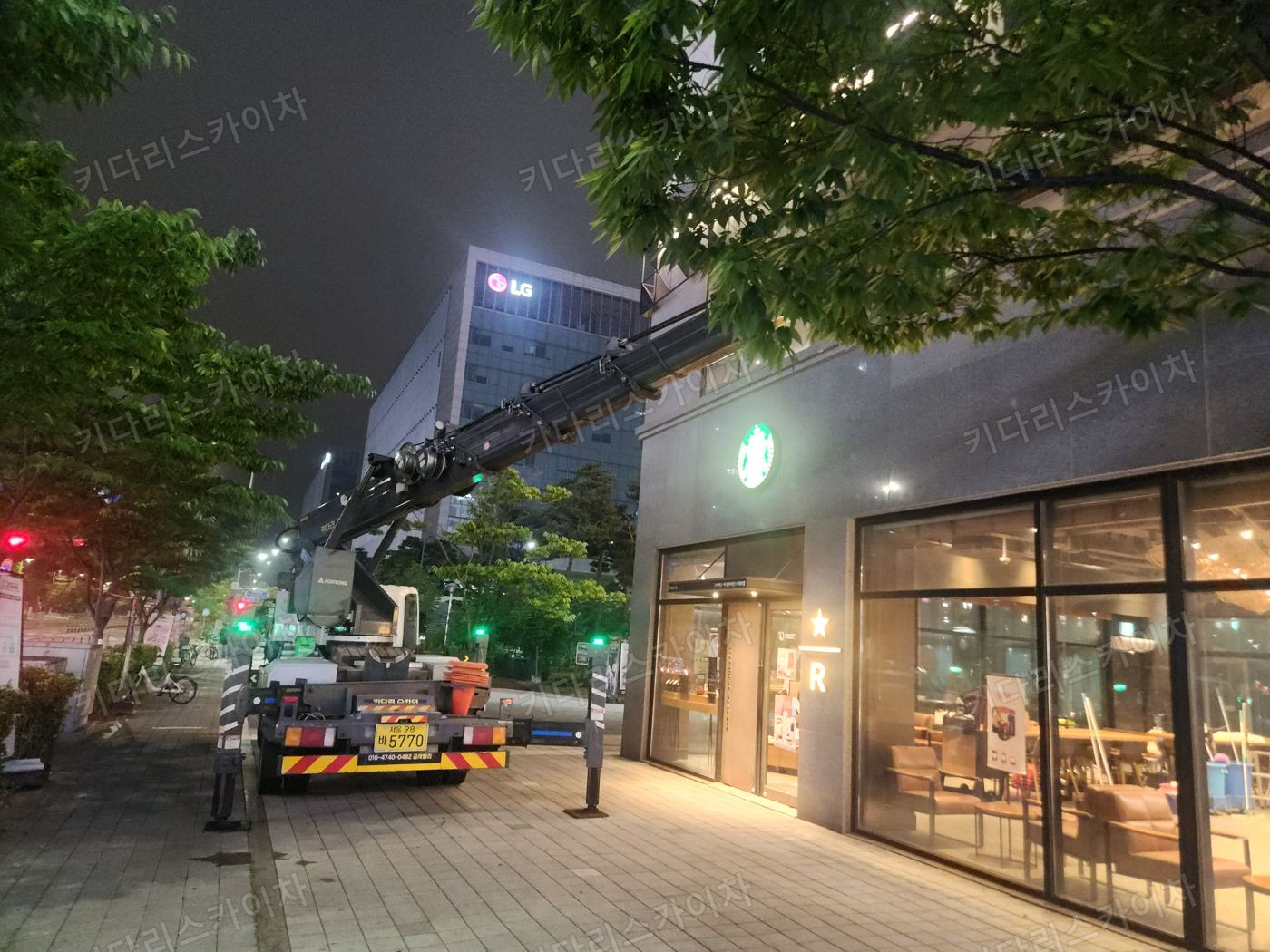 조명이 켜진 상가 외벽 앞 야간 장비 배치