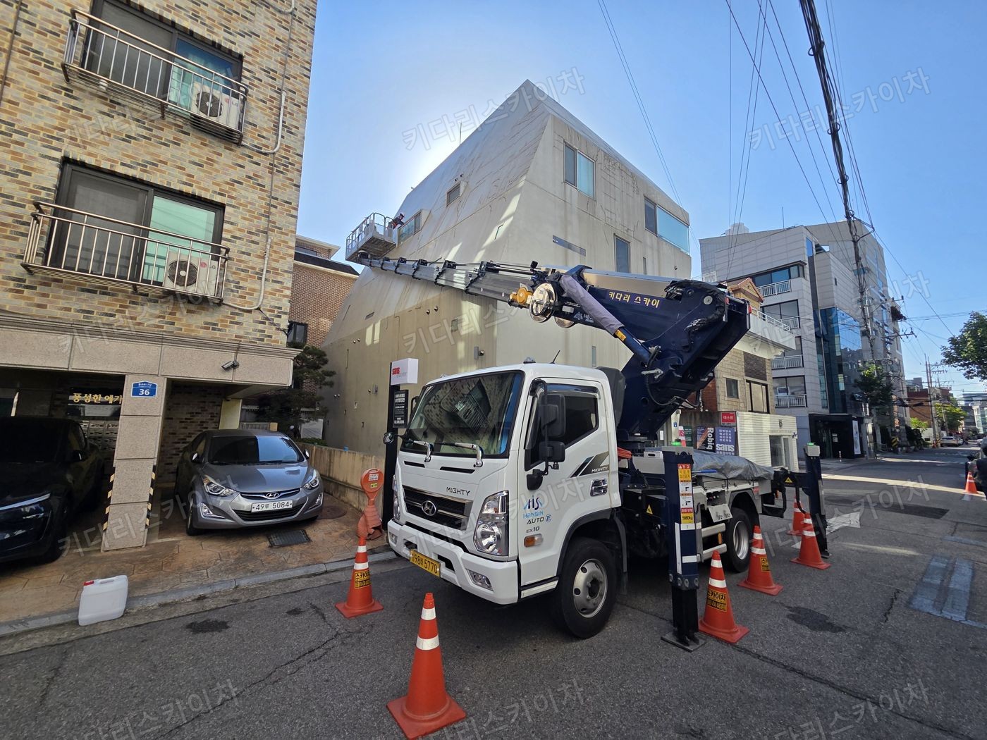 벽돌 건물 앞 스카이차 배치